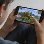 adolescent jouant a Minecraft sur smartphone Android