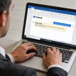 Employe tapant un message dauto reponse sur Outlook