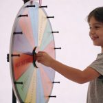 enfant souriant tournant une grande roue coloree