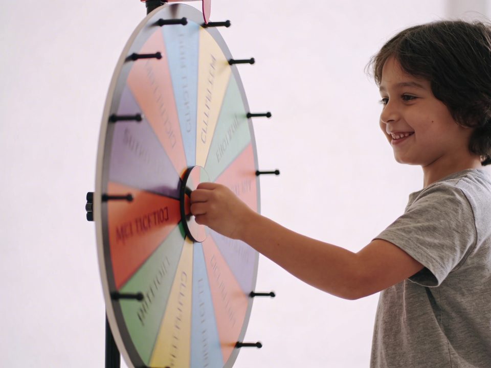 enfant souriant tournant une grande roue coloree