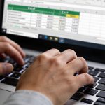 mains tapant au clavier devant ecran excel