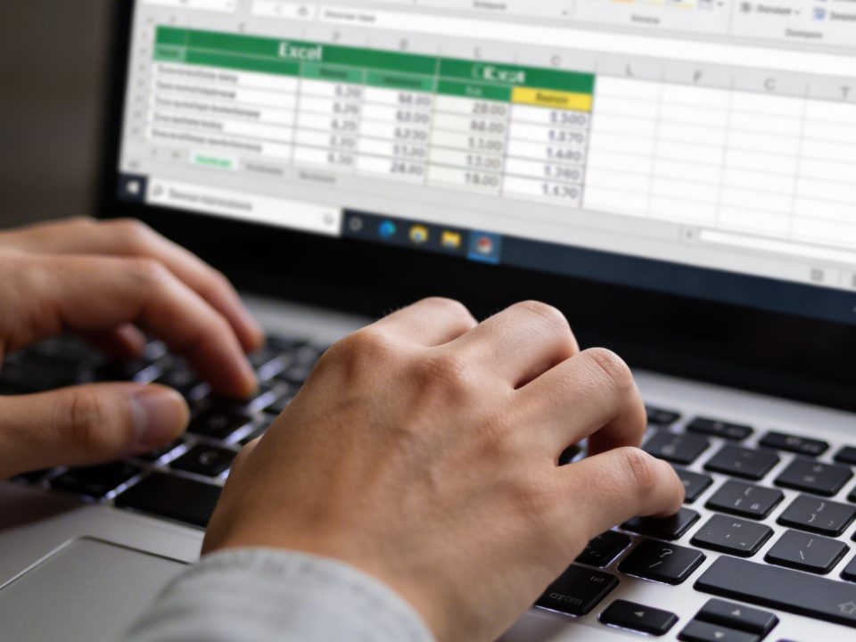 mains tapant au clavier devant ecran excel