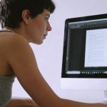 personne assise devant ordinateur analysant photo de texte