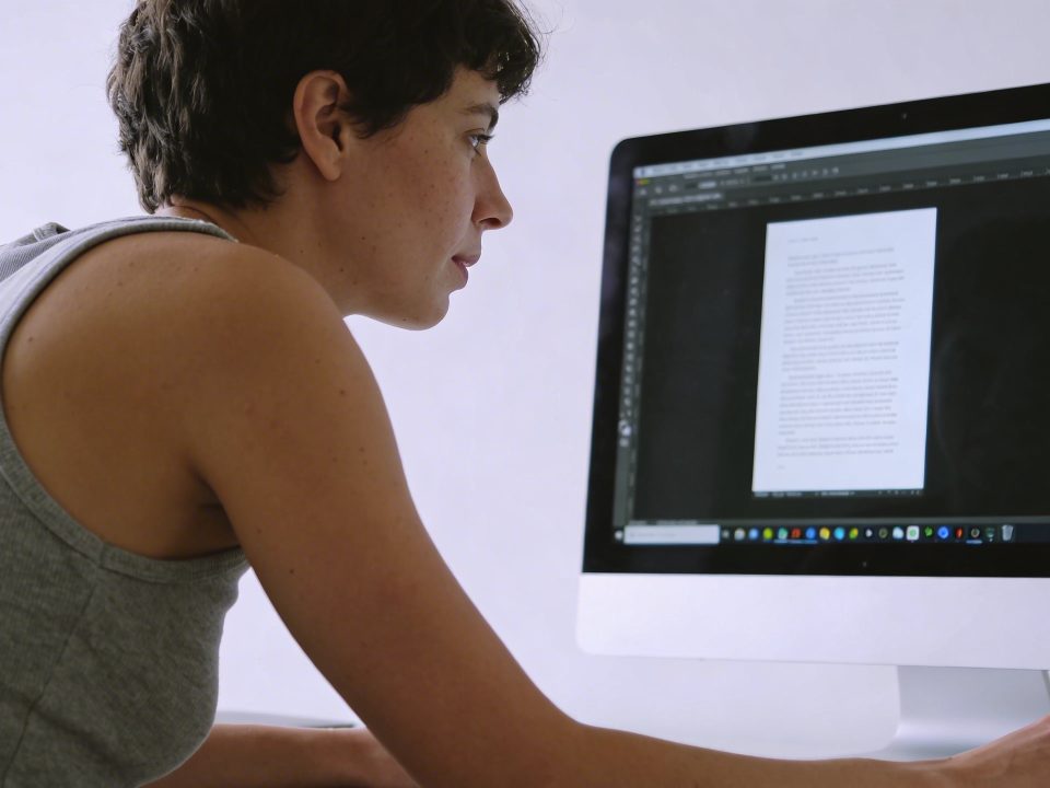 personne assise devant ordinateur analysant photo de texte