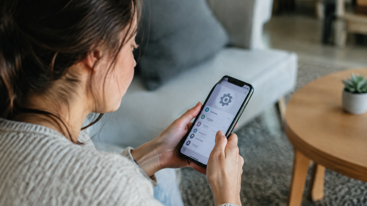 Utilisateur tenant smartphone effectuant reglages systeme