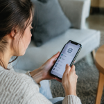 Utilisateur tenant smartphone effectuant reglages systeme