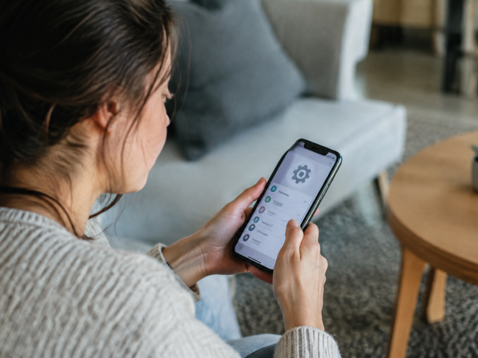 Utilisateur tenant smartphone effectuant reglages systeme