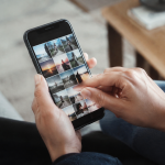 Mains tenant smartphone noir naviguant ecran tactile